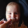 baby, pacifier, hand, infant, seatbelt, car_seat, child, face, expression, clothing, star_pattern, baby_clothes, person, portrait, closeup, indoor, skin, eyes, cute, young
