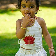 Izabella is registered to the contest to win money with this photo: child, closeup, cute, daylight, fashion, gold_bracelet, grass, happy, nature, necklace, outdoor, person, playful, portrait, smiling, sunlight, toddler, traditional_clothing, white_dress, young_child