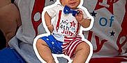 Zachary is registered to the contest to win money with this photo: 4th_of_july, american_flag, baby, blue, bow_tie, celebration, child, clothing, cute, face, hands, legs, patriotic, portrait, red, sitting, smiling, stars, stripes, white