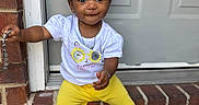 Jalena joined the competition — help win amazing prizes! toddler, child, curly_hair, yellow_bows, white_tshirt, yellow_shorts, sneakers, brick, doorstep, chain, smile, outdoor, portrait, cute, sitting, accessory, happy, person, casual_clothing, daylight