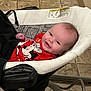 baby, infant, smile, red_shirt, mickey_mouse, baby_rocker, indoor, floor_tiles, happy, child, cute, person, young, clothing, seat, head, face, relaxing, home, comfort