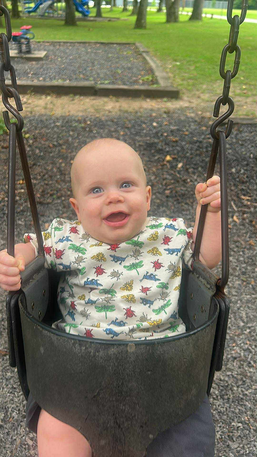 Kenneth is registered to the contest to win money with this photo: baby, child, swing, playground, outdoor, smiling, happy, grass, park, chains, seat, infant, person, clothing, shorts, nature, daylight, play, fun, casual