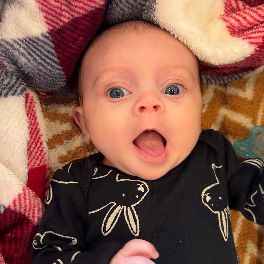 Whinter is registered to the contest to win money with this photo: baby, blanket, bodypart, clothing, couch, face, finger, furniture, hand, head, homedecor, knitwear, mouth, newborn, person, photography, portrait, quilt, sweater, t_shirt