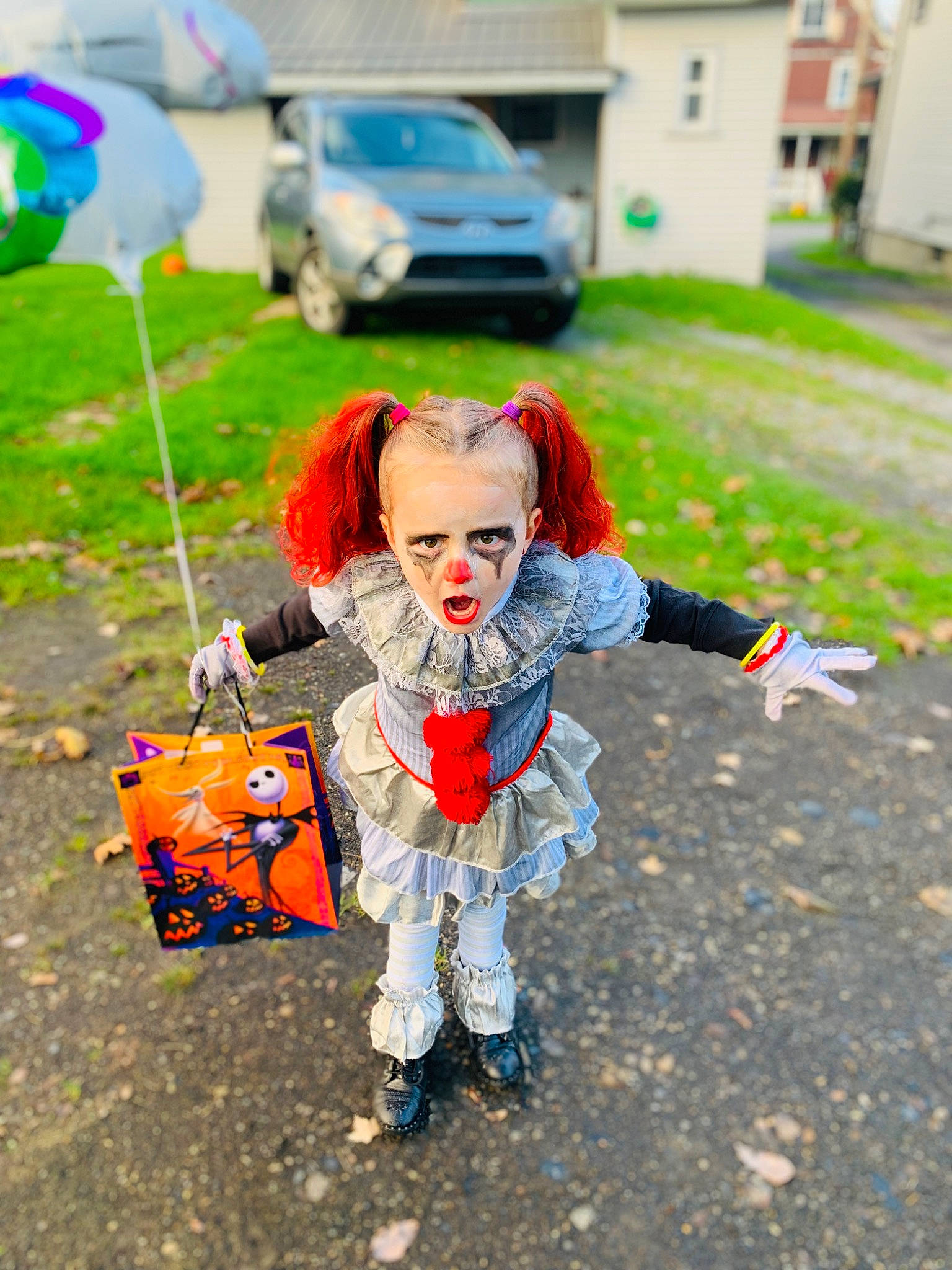 Lorelai is registered to the contest to win money with this photo: asphalt, balloon, car, child, costume, event, fashion_accessory, fictional_character, fun, grass, green, happy, leisure, orange, person, recreation, road, soil, sunglasses, toy