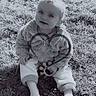 baby, black_and_white, child, cute, face, feet, grass, head, infant, jacket, nature, outdoor, pants, playful, portrait, sitting, smile, sock, toy, warm_clothing