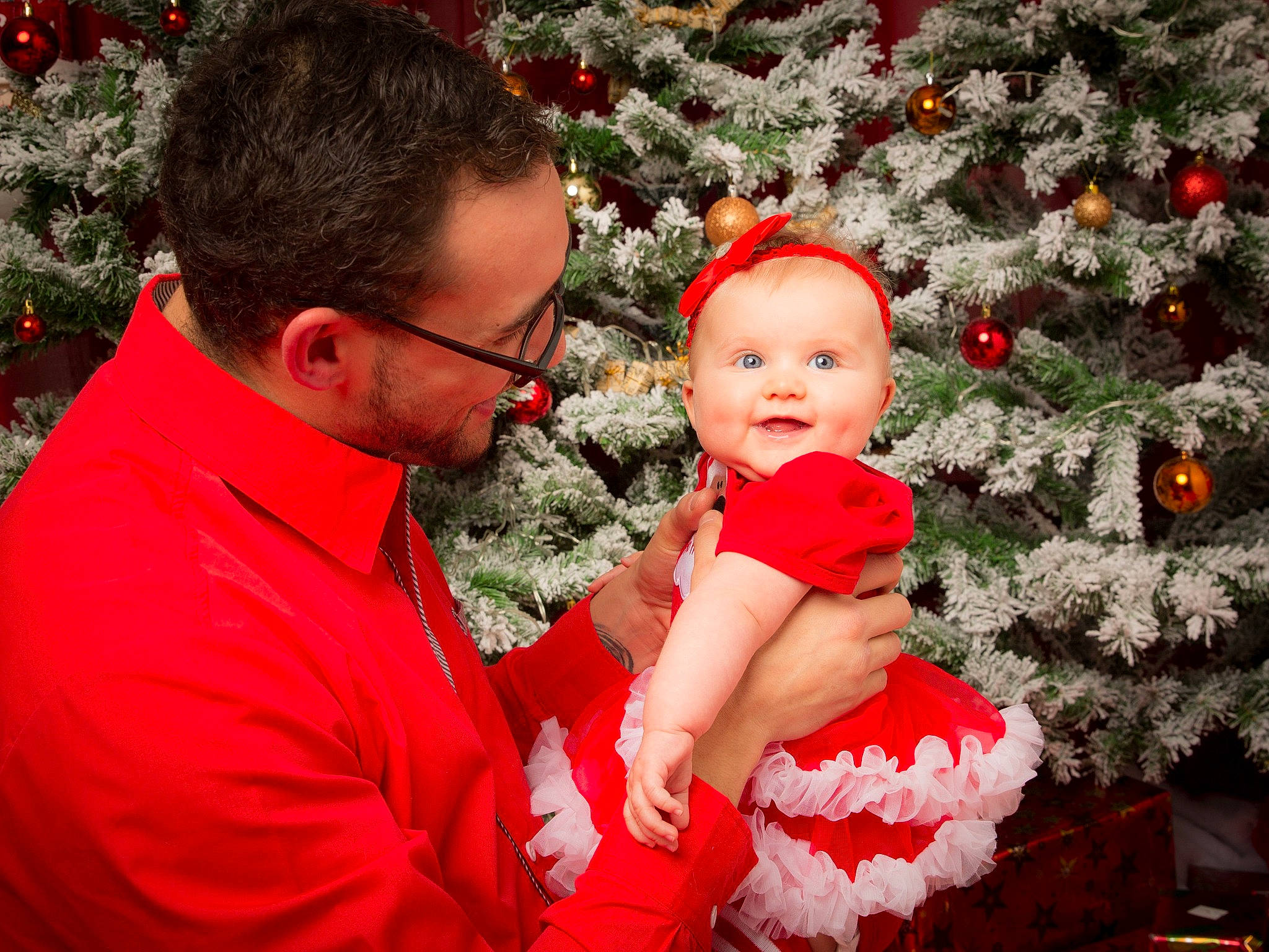Amélia participe au concours pour gagner de l'argent avec cette photo : baby, child, christmas, christmas_decoration, christmas_eve, christmas_ornament, christmas_tree, event, family, fictional_character, happy, holiday, lap, person, plant, red, santa_claus, smile, toddler, tree