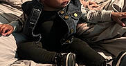 Starr joined the competition — help win amazing prizes! baby, child, headband, denim_jacket, black_clothing, sneakers, bed, blanket, pillow, indoor, cute, portrait, sitting, curious, young_child, fashion, cozy, soft_lighting, infant, expression