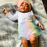 Ithalam Isipho is registered to the contest to win money with this photo: baby, infant, girl, headband, flower, unicorn, tutu, rainbow, blanket, star_pattern, sleeping, white_clothing, cute, soft_texture, relaxed, indoors, child, portrait, peaceful, smiling