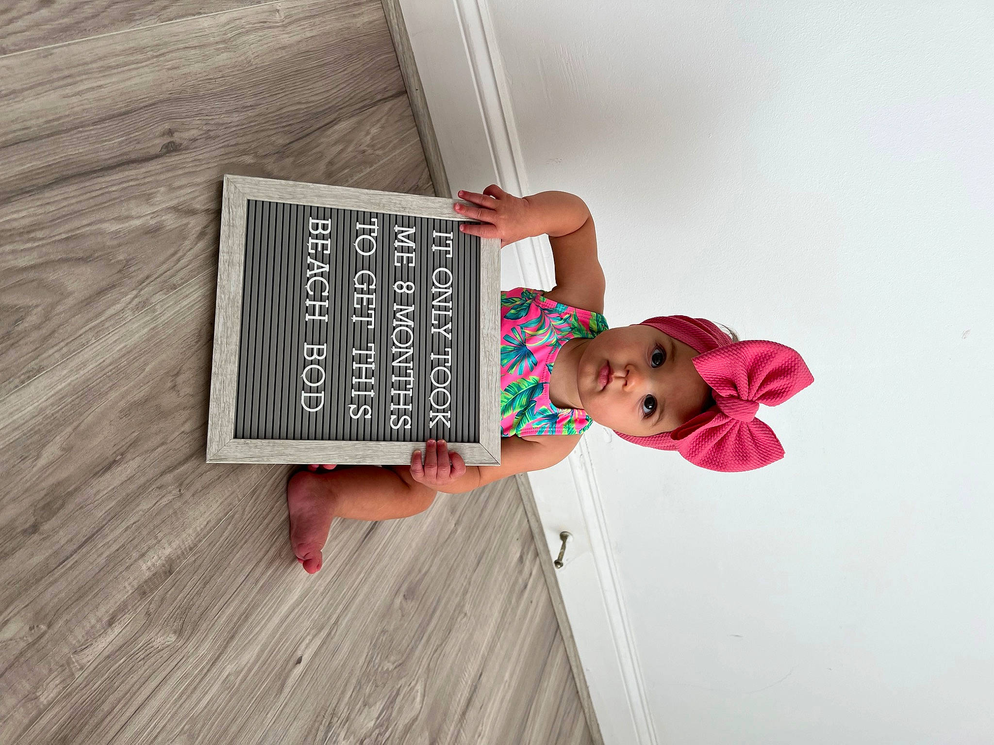 Hadley is registered to the contest to win money with this photo: blackboard, book, bookcase, child, fashion_design, flooring, font, happy, hardwood, headwear, magenta, pattern, person, publication, room, shelf, shelving, visual_arts, wood, wood_flooring