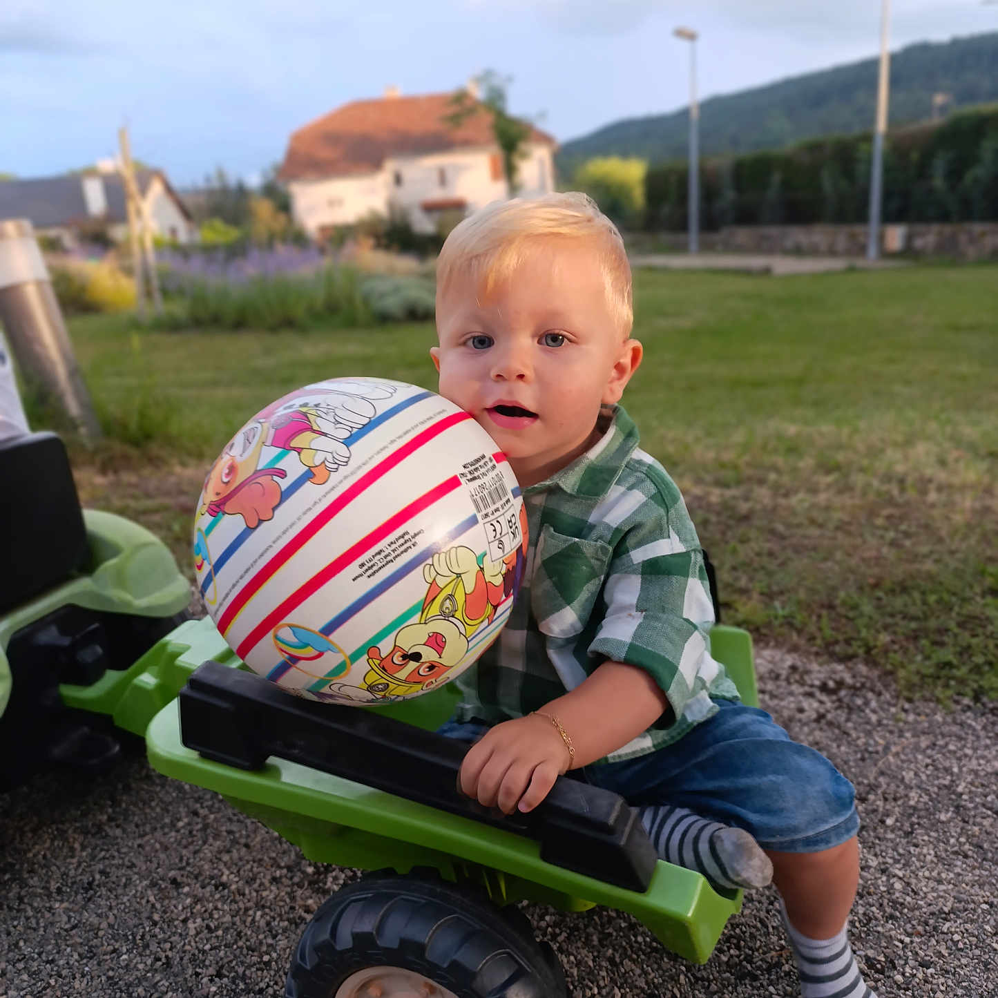 Nolan participe au concours pour gagner de l'argent avec cette photo : accessories, baby, ball, clothing, face, football, grass, head, pants, person, photography, plant, portrait, rugby, rugbyball, sitting, soccer, soccerball, sphere, sport