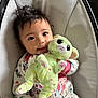 Nevaeh is registered to the contest to win money with this photo: baby, child, plush_toy, green_bunny, cushion, seat, clothing, patterned_outfit, smiling, happy, indoor, portrait, cute, infant, hand, face, eyes, hair, soft_toy, comfort