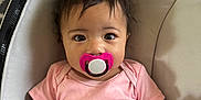 Nevaeh joined the competition — help win amazing prizes! baby, infant, pacifier, pink_onesie, baby_seat, cushion, child, cute, portrait, indoors, person, hair, wide_eyes, comfort, seatbelt, hand, expression, small_child, skin, young