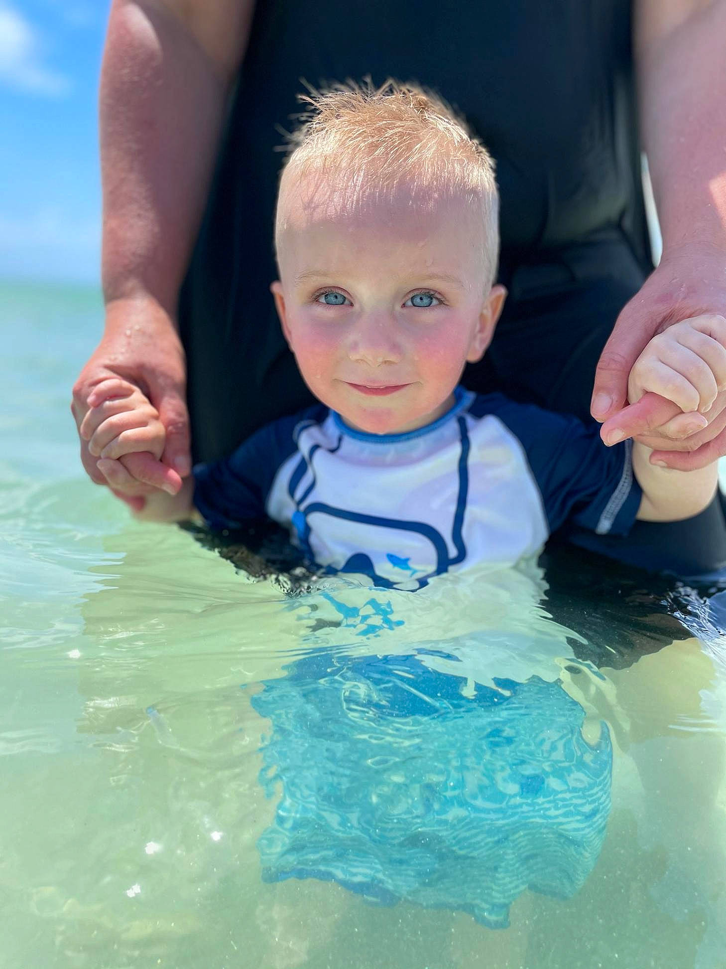 Ashton is registered to the contest to win money with this photo: aqua, azure, baby, bathing, electric_blue, finger, fun, gesture, hair, hand, happy, head, leisure, person, personal_protective_equipment, recreation, skin, smile, swimming_pool, toddler