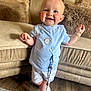 Blayn joined the competition — help win amazing prizes! baby, child, smiling, blue_shirt, shorts, white_sneakers, pacifier_clip, living_room, couch, pillows, wooden_floor, happy, standing, cute, indoor, person, face, plush, home, cozy