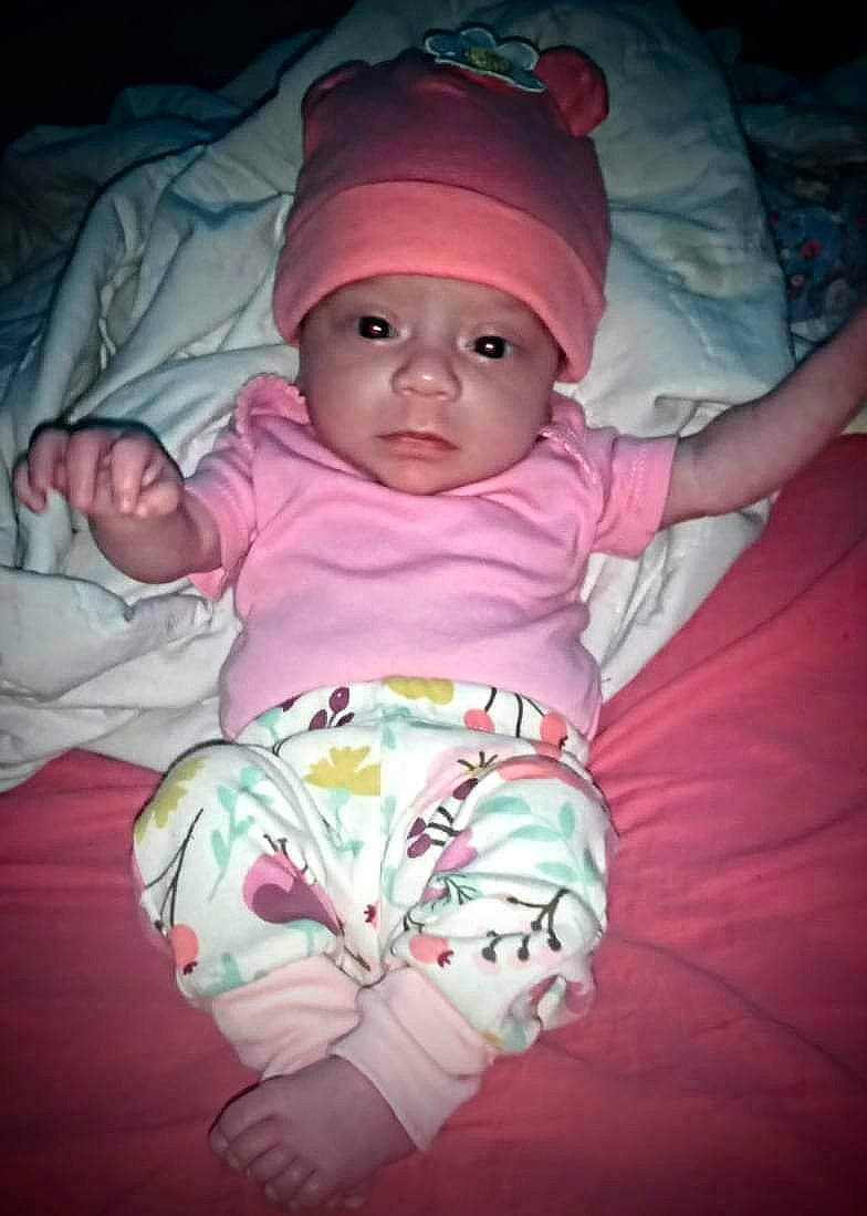 Magnolia is registered to the contest to win money with this photo: baby, baby_toddler_clothing, cheek, comfort, darkness, eye, finger, fun, headwear, iris, lip, magenta, mouth, nose, person, pink, purple, sitting, skin, sleeve