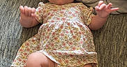 Bonnie joined the competition — help win amazing prizes! arms, baby, bow, child, couch, cute, expression, fabric, floral_dress, hands, headband, indoors, infant, laying_down, legs, person, pillow, skin, textile, young