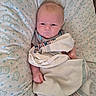 baby, blanket, pillow, infant, cute, face, expression, pattern, bear, dots, clothing, lying_down, newborn, swaddled, child, soft, indoor, portrait, wrapped, resting