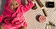 Romy a rejoint le concours — aidez-le/la à gagner de superbes lots ! baby, beauty_products, blanket, bow, child, cosmetics, cute, face, happy, indoors, infant, lotion, perfume, person, pink_robe, portrait, powder, skin_care, smiling, texture
