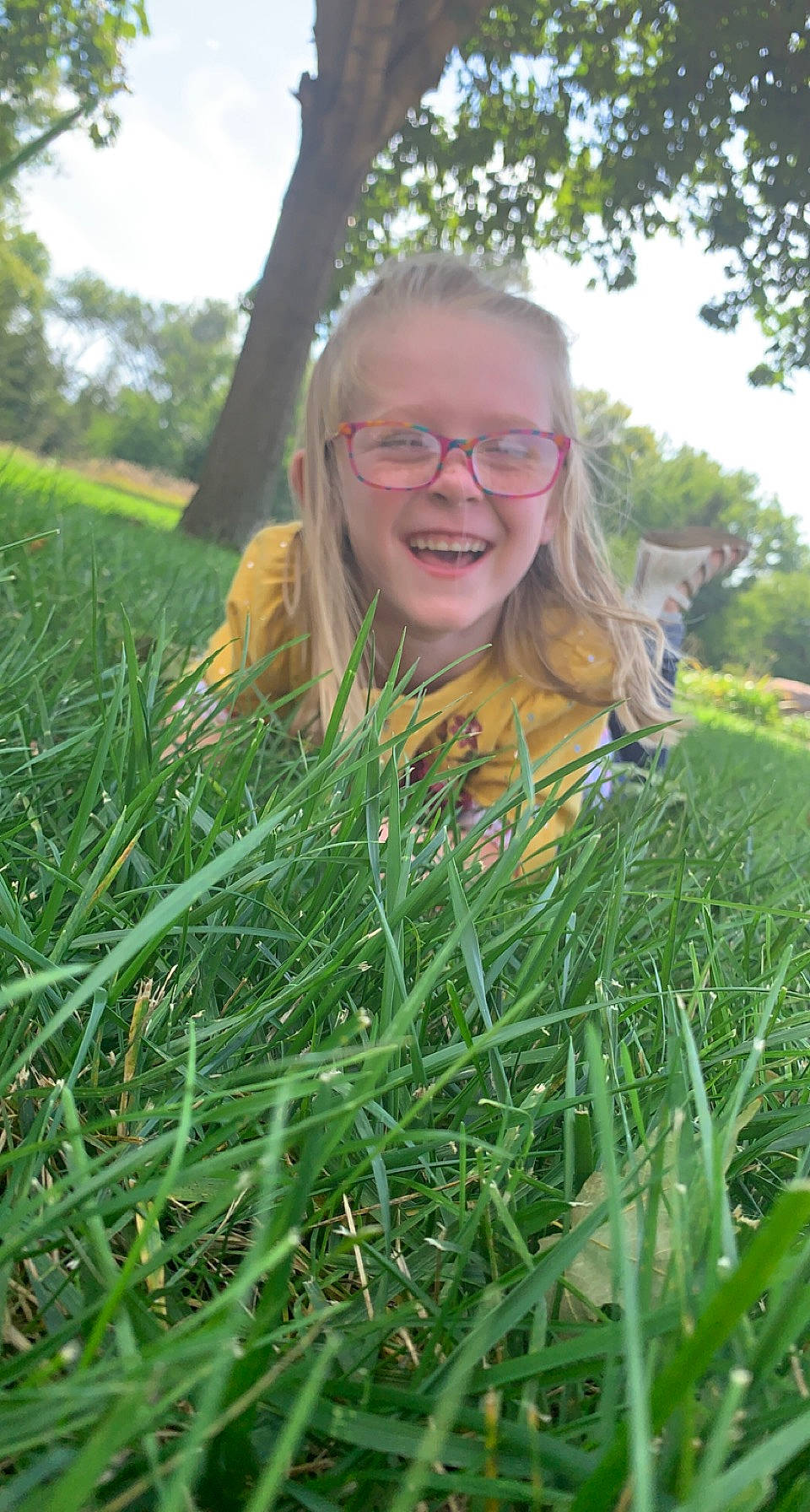 Henzley is registered to the contest to win money with this photo: flowering_plant, fun, glasses, grass, grass_family, grassland, happy, joy, landscape, leisure, long_hair, meadow, people_in_nature, person, plant, prairie, sky, smile, summer, terrestrial_plant