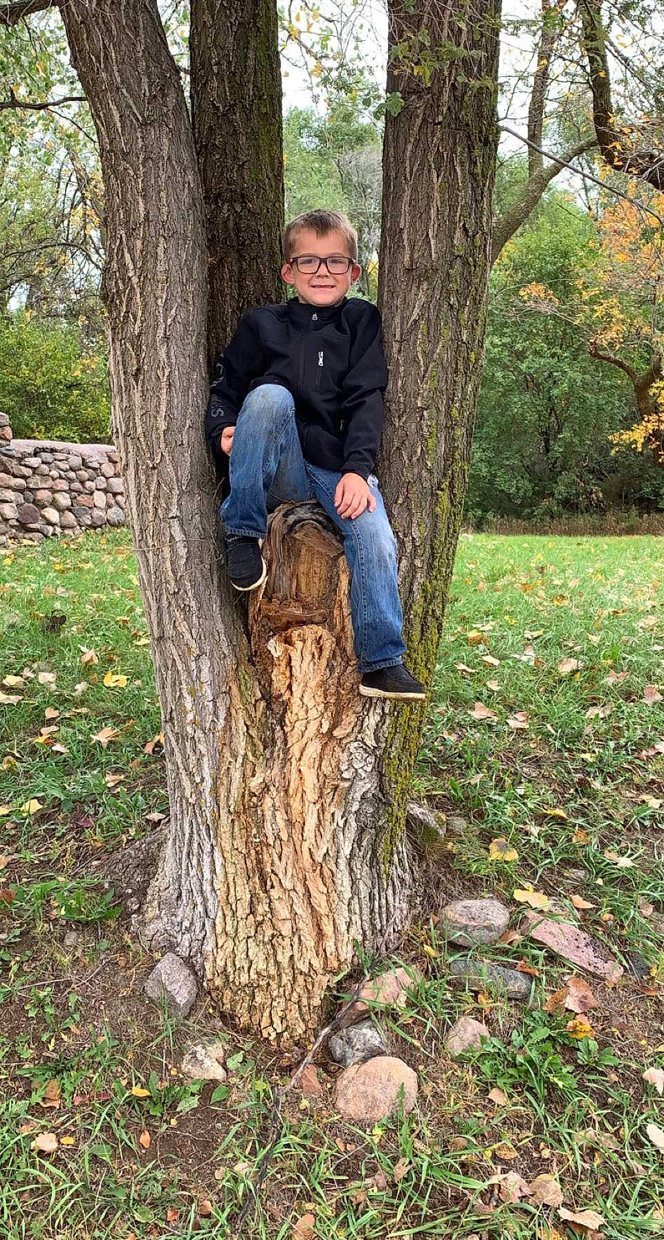 Brynlee is registered to the contest to win money with this photo: boot, branch, clothing, deciduous, denim, forest, grass, happy, jeans, joy, leg, outerwear, people_in_nature, person, plant, shoe, smile, sneakers, tree, trunk
