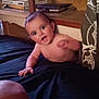 baby, child, indoor, furniture, shelf, books, container, wood, curtain, person, smiling, shirtless, black_fabric, face, hand, head, eyes, mouth, expression, room