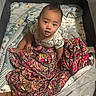 baby, infant, playpen, blanket, colorful, child, cute, indoors, sitting, looking_up, clothing, patterned_blanket, soft_toys, expression, young_child, portrait, floor, comfort, home, curious