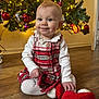 baby, child, christmas_tree, ornaments, red_booties, plaid_dress, white_tights, holiday, festive, smiling, indoor, wooden_floor, decorations, lights, cute, portrait, seasonal, celebration, happy, infant