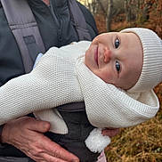 Ava joined the competition — help win amazing prizes! baby, child, adult, person, outdoor, forest, trees, fall, autumn, knitwear, hat, baby_carrier, smile, face, hand, nature, warm_clothing, grass, daylight, parent