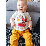 Yaël participe au concours pour gagner de l'argent avec cette photo : baby, blanket, blue_eyes, child, couch, crib, cute, face, furniture, home, indoor, infant, light_hair, portrait, seated, smiling, socks, toy, tshirt, yellow_pants