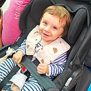 Loan participe au concours pour gagner de l'argent avec cette photo : baby, car_seat, smile, child, striped_clothing, bib, seatbelt, toy, giraffe_toy, pink_pillow, happy, infant, cute, face, safety, child_seat, indoor, young_child, holding, clothing
