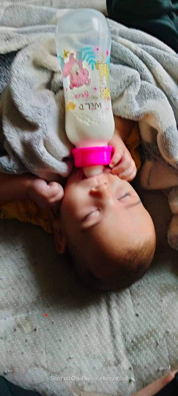 Athena joined the competition — help win amazing prizes! baby_products, drinkware, eyelash, finger, gesture, hand, human_body, human_leg, leg, lip, nail, neck, nose, person, pink, plastic_bottle, skin, textile, thumb, toddler