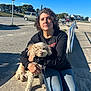 Truffles joined the competition — help win amazing prizes! woman, dog, outdoor, sunny, concrete, blue_sky, casual, holding, pet, leash, parking_lot, car, bench, jeans, black_shirt, curly_hair, daytime, sidewalk, residential, nature