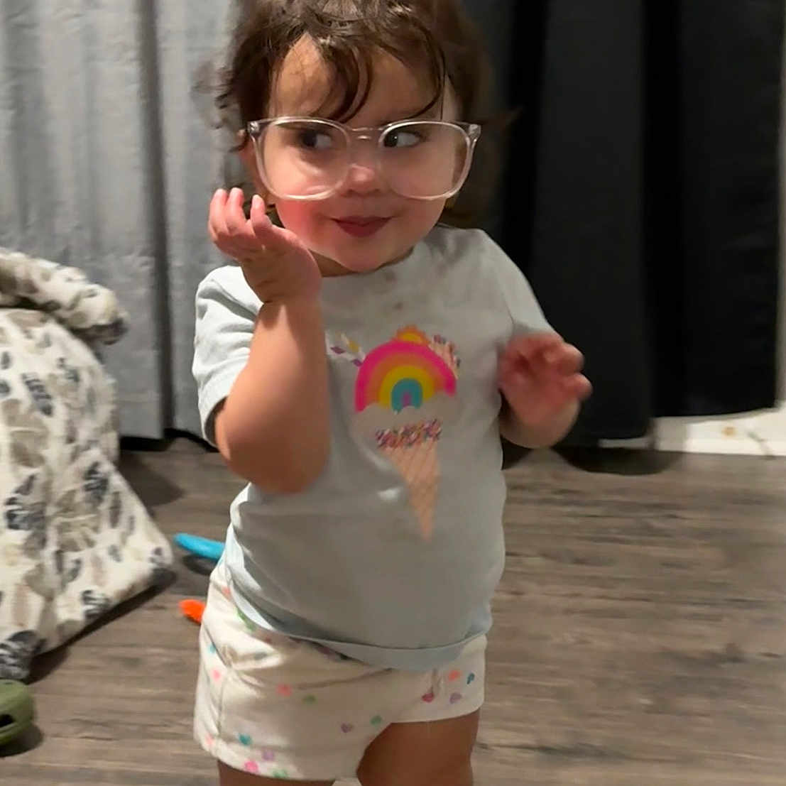 Violet is registered to the contest to win money with this photo: accessories, baby, bodypart, clothing, diaper, face, finger, footwear, glasses, hand, head, hosiery, person, photography, portrait, shoe, shorts, sock, sunglasses, t_shirt