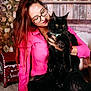 Aïko a rejoint le concours — aidez-le/la à gagner de superbes lots ! woman, cat, black_cat, glasses, pink_shirt, holiday_decor, christmas_tree, ornaments, festive, indoor, carpet, wooden_background, mailbox, decorations, smiling, long_hair, sitting, pet, cozy, warm_lighting