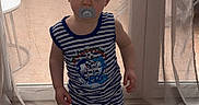 Thélyo a rejoint le concours — aidez-le/la à gagner de superbes lots ! bare_legs, blue_and_white, child, clogs, curtains, home_interior, indoor, neutral_expression, one_person, pacifier, portrait, short_hair, sliding_door, socks, standing, striped_outfit, tile_floor, toddler, window, young_child