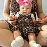 baby, child, infant, portrait, sitting, pink_bow, leopard_print, dress, white_socks, adult, parent, hands, fashion, indoors, close_up, face, eyes, cute, family, photography