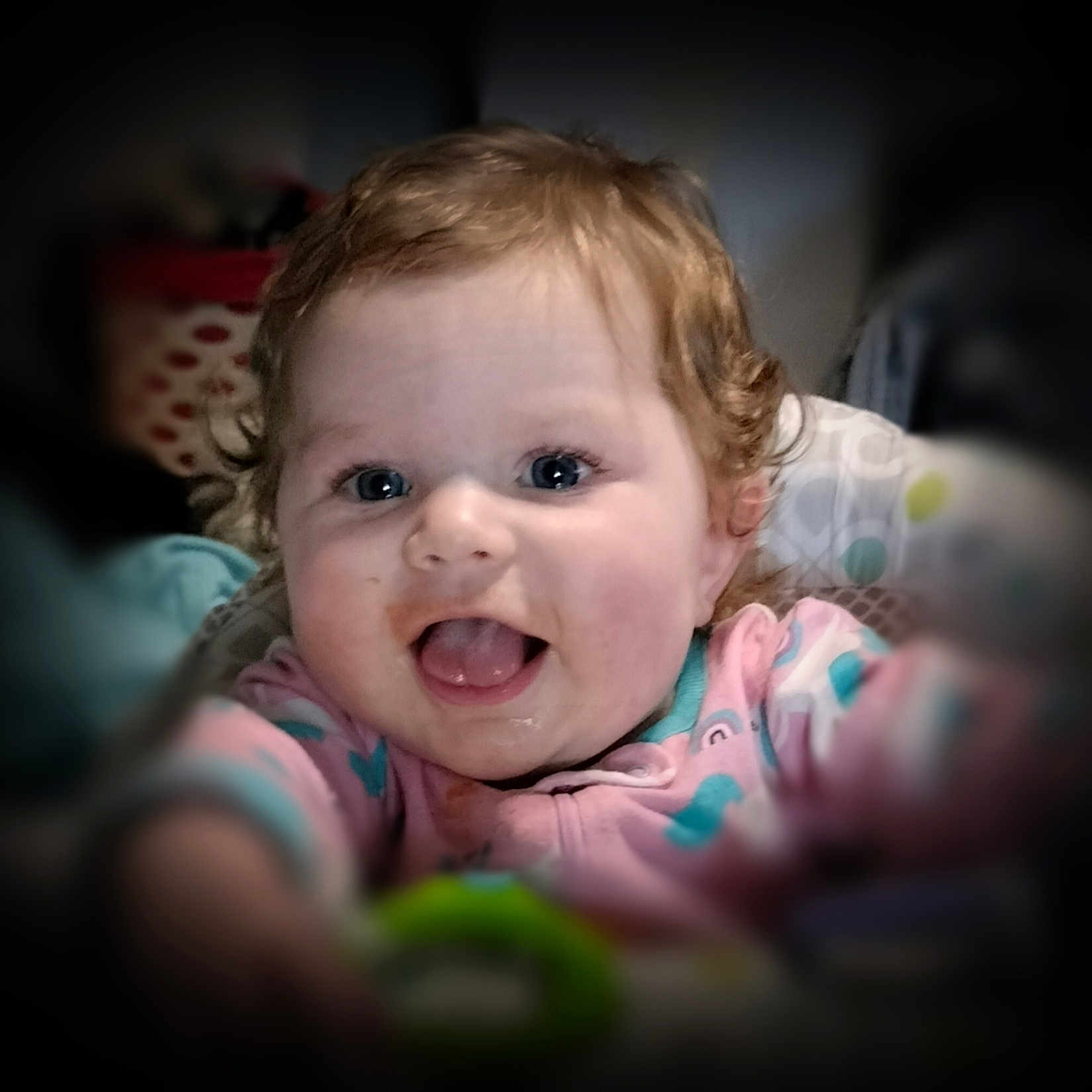 Charlie-Lynn joined the competition — help win amazing prizes! baby, baby_toy, blue_eyes, blurred_background, child, closeup, curly_hair, cute, expression, face, happy, indoor, infant, joyful, onesie, person, portrait, reaching, smiling, soft_focus