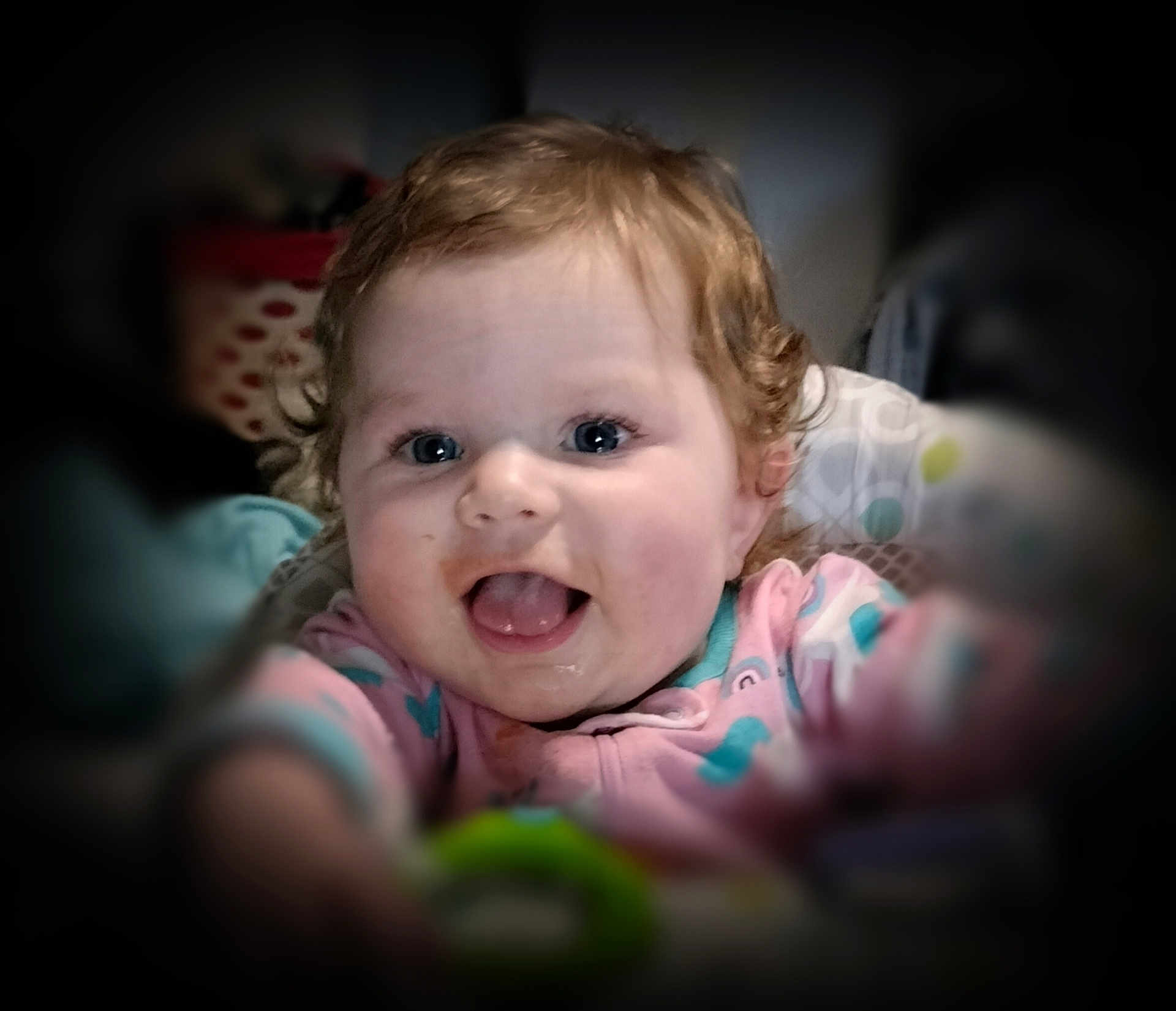 Charlie-Lynn joined the competition — help win amazing prizes! baby, child, smiling, happy, curly_hair, blue_eyes, onesie, reaching, portrait, indoor, closeup, cute, infant, face, person, soft_focus, expression, joyful, baby_toy, blurred_background