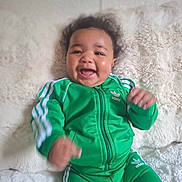 Isaïa participe au concours pour gagner de l'argent avec cette photo : adidas, baby, blanket, child, clothing, cozy, curly_hair, cute, face, green_tracksuit, hands, happy, indoor, infant, lying_down, motion_blur, portrait, smiling, soft_texture, young_child