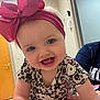 baby, child, headband, pink_bow, hello_kitty, patterned_clothing, smiling, blue_eyes, indoor, hand, person, cute, happy, toddler, short_sleeves, infant, closeup, portrait, skin, human