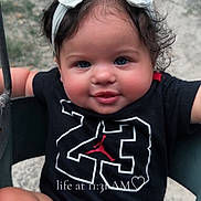 Rayleigh is registered to the contest to win money with this photo: baby, child, face, headband, bow, smile, sitting, swing, outdoor, grass, shirt, number, cute, happy, portrait, person, infant, playful, skin, hair