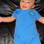 baby, black_leather, blue_clothing, child, couch, cute, eyes, face, furniture, happy, head, indoor, infant, legs, person, romper, skin, smiling, tongue_out, young