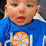 Muhammad Ali is registered to the contest to win money with this photo: baby, child, face, eyes, mouth, blue_shirt, orange_graphic, infant, closeup, portrait, cute, skin, head, expression, person, young, indoors, clothing, tshirt, childhood