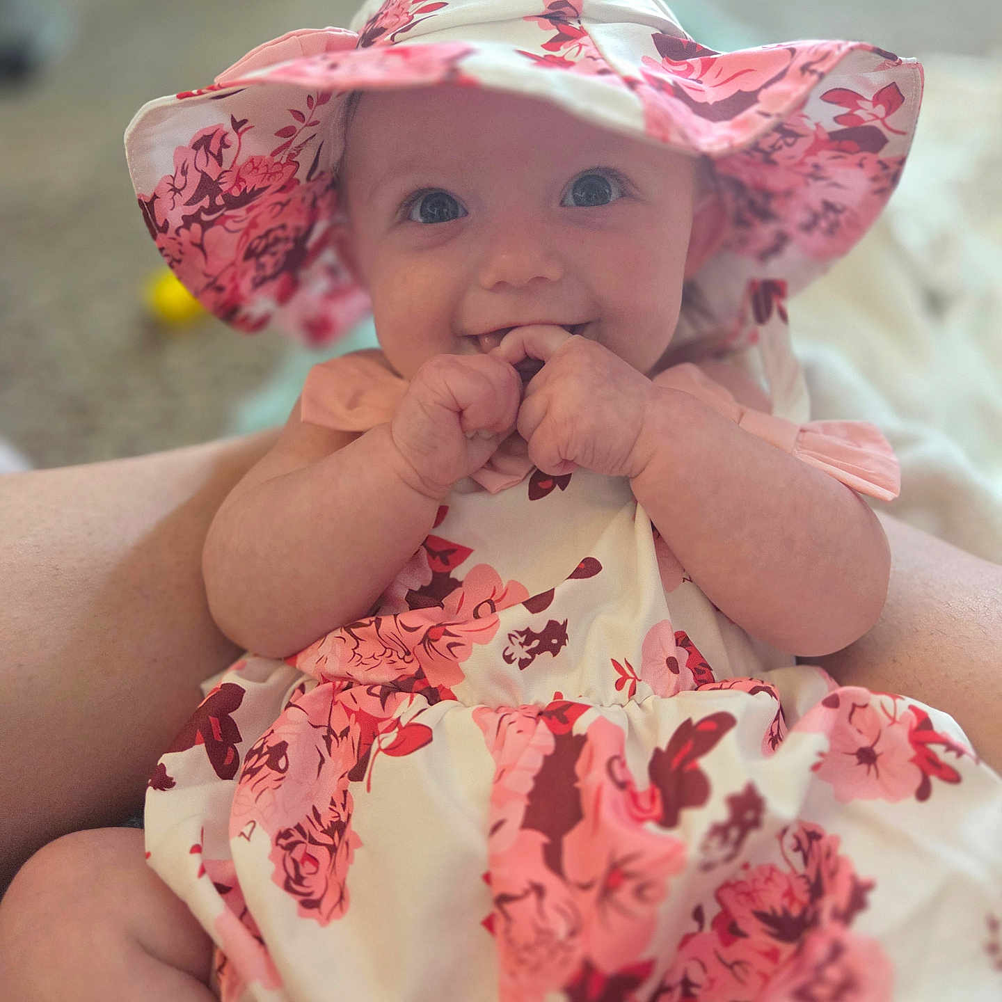 Rosalie joined the competition — help win amazing prizes! baby, child, infant, portrait, smiling, happy, floral_hat, sunhat, floral_dress, pink, clothing, sitting, hands, fingers, indoor, adult, holding, closeup, photography, cute