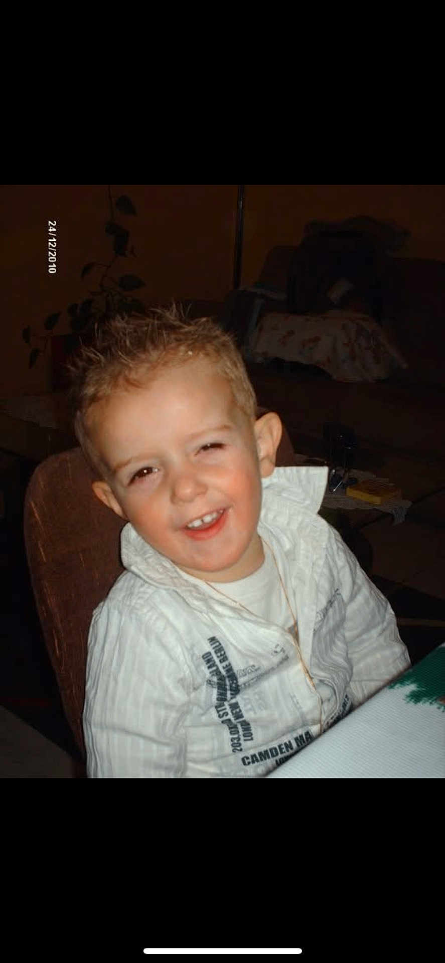 Leo participe au concours pour gagner de l'argent avec cette photo : child, boy, smiling, indoor, white_shirt, spiky_hair, table, chair, plant, furniture, happy, portrait, casual_clothing, person, dining_room, young, cute, face, sitting, light