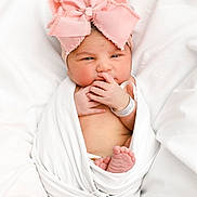 Isabella is registered to the contest to win money with this photo: baby, newborn, infant, pink_bow, headband, wrapped, blanket, white_background, cute, tiny_feet, hand, portrait, sleepy, indoors, soft_light, closeup, baby_wrapped, newborn_baby, child, adorable