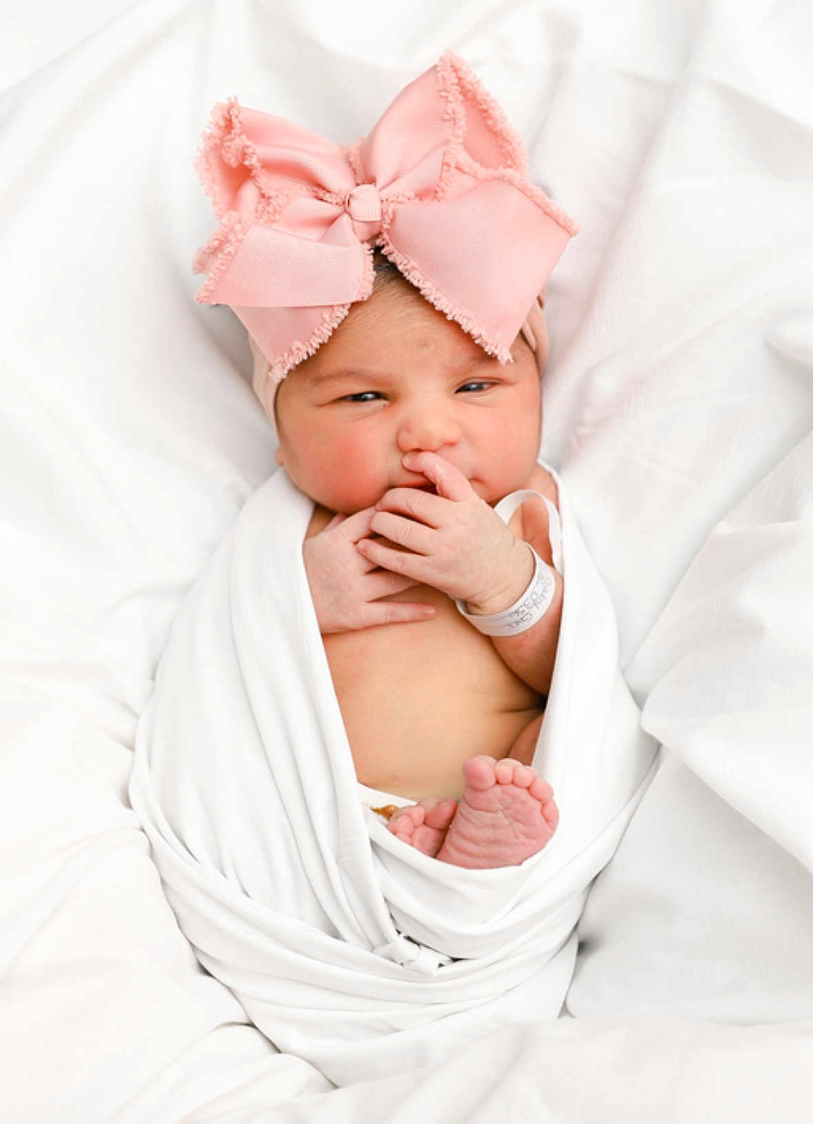 Isabella is registered to the contest to win money with this photo: baby, newborn, infant, pink_bow, headband, wrapped, blanket, white_background, cute, tiny_feet, hand, portrait, sleepy, indoors, soft_light, closeup, baby_wrapped, newborn_baby, child, adorable