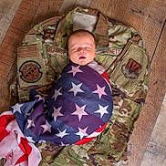 Cade joined the competition — help win amazing prizes! newborn, baby, flag, american_flag, camouflage, military_uniform, wooden_floor, sleeping, wrapped, infant, peaceful, portrait, person, flooring, fabric, indoor, closeup, resting, soft, symbolic