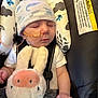 baby, infant, sleeping, car_seat, nasal_tube, hat, plush_toy, bunny, child, warning_label, safety_harness, cute, resting, indoors, soft_toy, newborn, peaceful, clothing, person, face