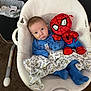 baby, blue_pajamas, baby_rocker, blanket, plush_toy, spiderman, toy, face, infant, carpet, medical_tube, indoor, person, child, fabric, comfort, seated, cute, home, soft_toys